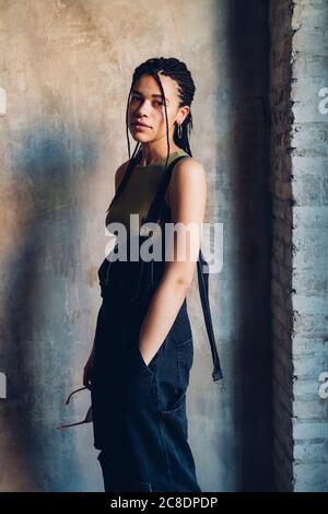 Portrait of a stylish young woman standing at a wall Stock Photo
