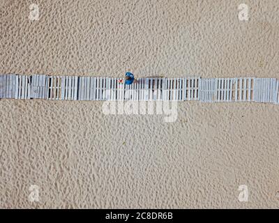 Man walking on boardwalk on beach, aerial view Stock Photo