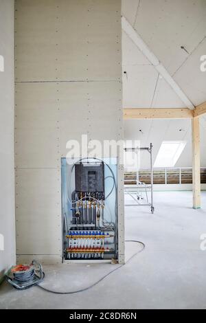 Cable extension reel and conduit for underfloor heating on construction site Stock Photo