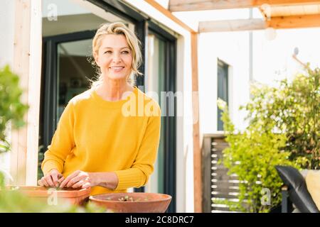 Portrait of mature woman gardening on terrace Stock Photo