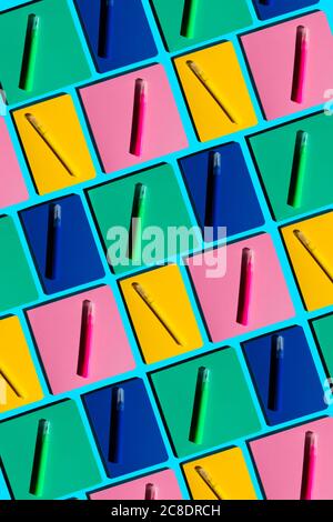 Pattern of colorful notebooks and matching felt tip pens Stock Photo