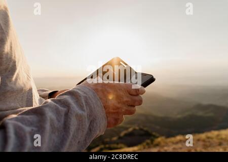 Retired senior man using phone during sunset Stock Photo
