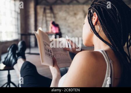 Young woman reading a book in loft office Stock Photo
