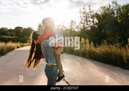 Mother holding her daughter on way outdoors Stock Photo