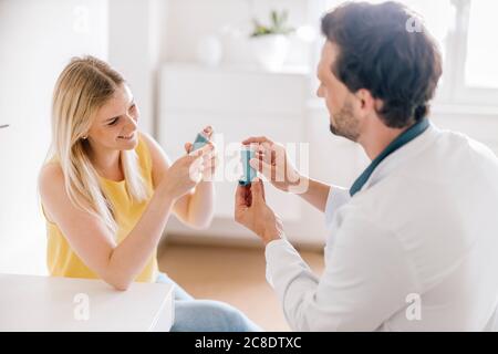 Doctor explaining using of asthma inhaler Stock Photo