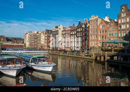 The Netherlands, North Holland Province, Amsterdam, Damrak, Tourboats and port buildings Stock Photo