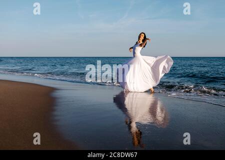 Ballerina in white dress dancing at the sea Stock Photo