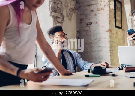 Creative team having business meeting in loft office using smartphones Stock Photo