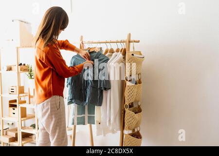 Female fashion designer working at home with clothes stand Stock Photo