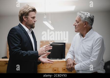 Business partners standing in office, talking Stock Photo