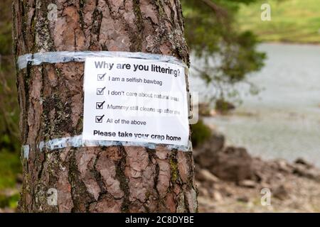 Litter problems constant problem in Loch Lomond and the Trossachs National Park during coronavirus pandemic - sign by Loch Chon asking why - Scotland Stock Photo