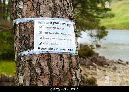 Litter problems constant problem in Loch Lomond and the Trossachs National Park during coronavirus pandemic - sign by Loch Chon asking why - Scotland Stock Photo