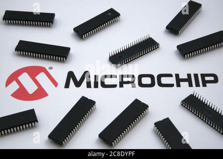 Stone / United Kingdom - July 23, 2020: Microchip company logo seen on the paper and microchips placed around. Selective focus. Stock Photo