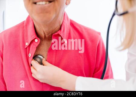 Female doctor examining senior patient in medical clinic Stock Photo