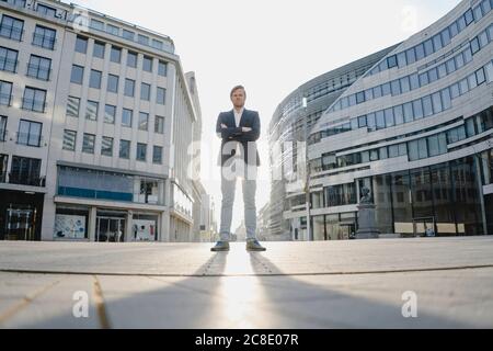 Businessman standing in the city at sunset Stock Photo