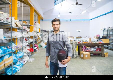 Portrait of a man holding fencing mask in a warehouse Stock Photo