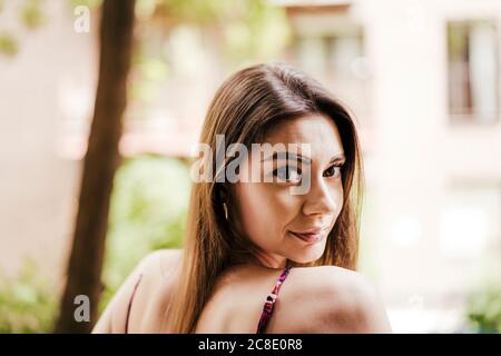 Beautiful woman looking over shoulder outdoors Stock Photo