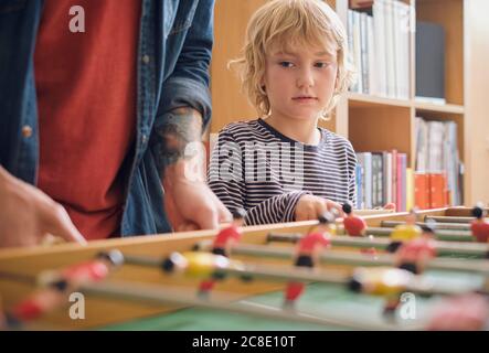 Father and son playing foosball at home Stock Photo