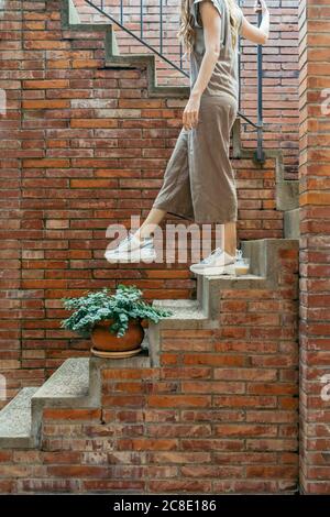 Young woman moving down on staircase Stock Photo