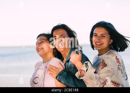 Happy mother enjoying with daughters against clear sky Stock Photo
