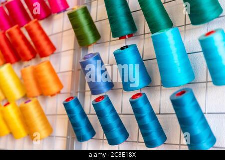 Close-up of colorful thread spools on rack at design studio Stock Photo