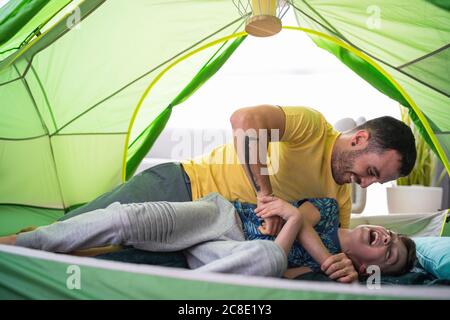 Father and son playing in tent at home Stock Photo
