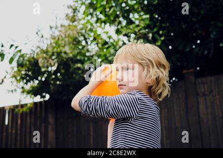 Boy playing basketball at yard Stock Photo