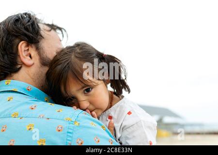 Portrait of little girl leaning on father's shoulder Stock Photo