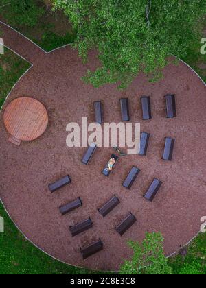 Aerial view of woman lying down on bench in park Stock Photo