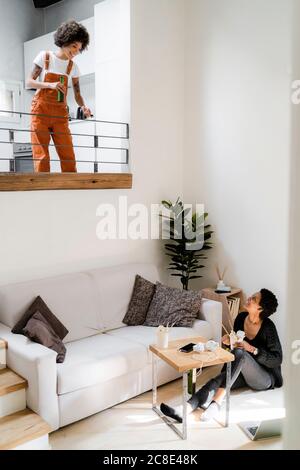 Two young women relaxing at home with Asian food and beer Stock Photo