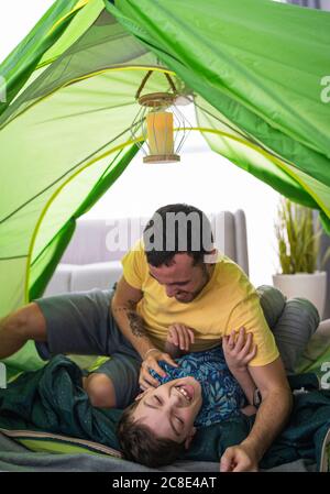 Father and son in tent at home Stock Photo