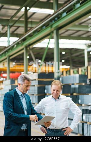 Two businessmen using tablet in a factory Stock Photo