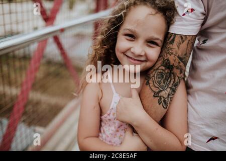 Close-up of daughter holding father’s hand on bridge Stock Photo