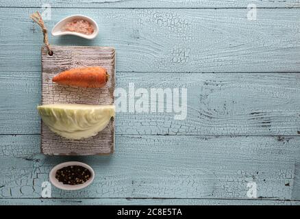 Wooden cabbage grater, piece of cabbage, carrot, assorted pepper and  himalayan salt on cutting board and on blue wooden table. Flat lay with  cabbage f Stock Photo - Alamy