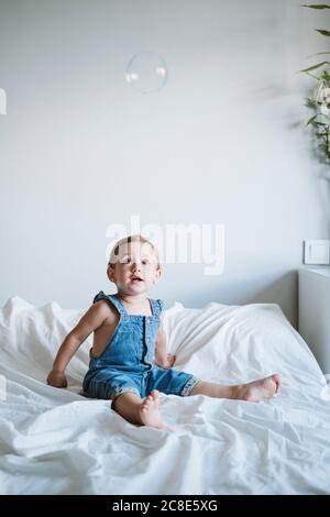 Baby girl playing with bubbles at home Stock Photo