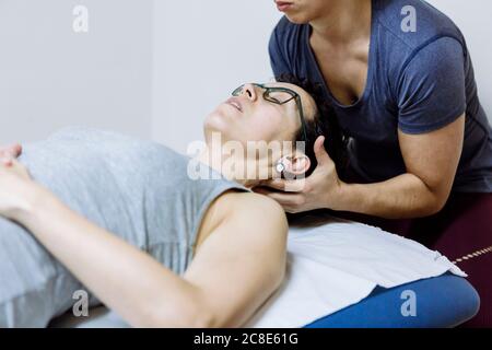 Female physiotherapist stretching leg of client Stock Photo