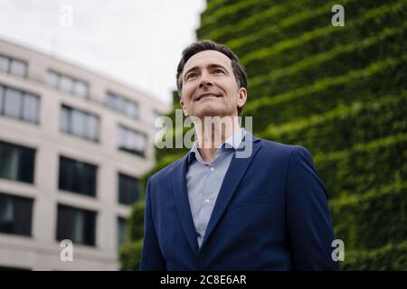 Portrait of a smiling mature businessman in the city looking up Stock Photo