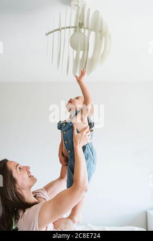 Mother playing with baby girl at home Stock Photo