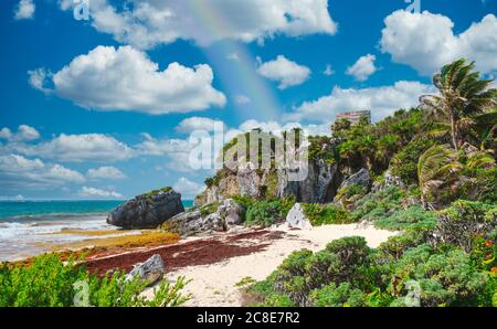 Summer day with a rainbow at a beautiful beach next to the mayan ruins of Tulum on the Mayan Riviera in Mexico Stock Photo