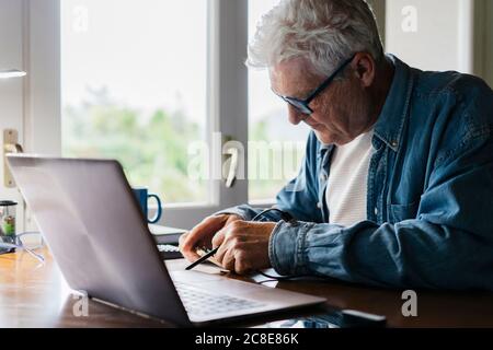 Senior man repairing laptop at home Stock Photo