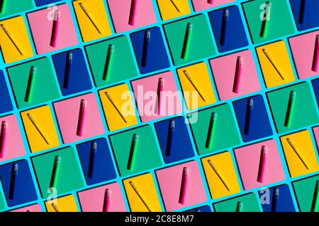 Pattern of colorful notebooks and matching felt tip pens Stock Photo