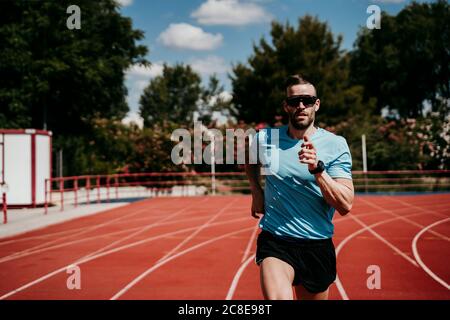 Male athlete running on tartan track Stock Photo