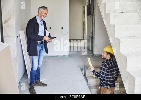 Smiling architect and worker on a construction site Stock Photo