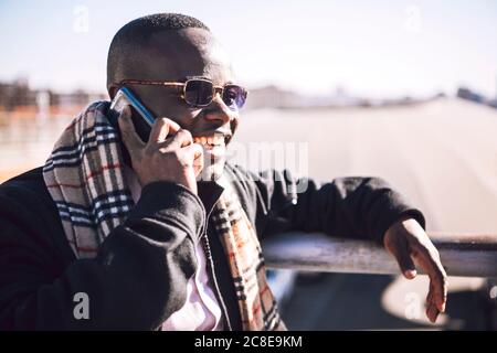 Close-up of stylish businessman talking over mobile phone during sunny day Stock Photo