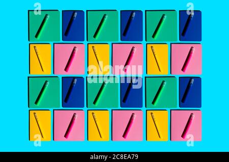 Pattern of colorful notebooks and matching felt tip pens Stock Photo