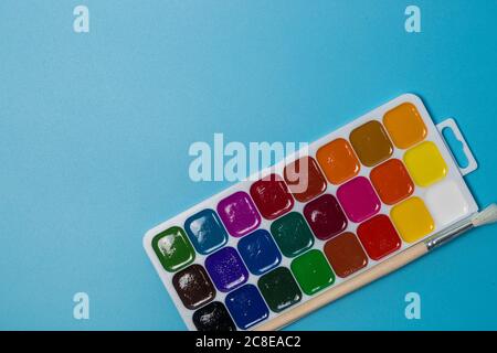 Watercolor paint set in the plastic box on blue background Stock Photo