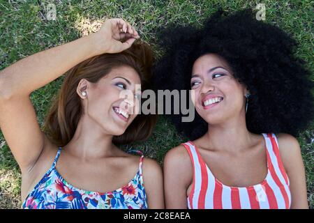 Girlfriends lying on meadow Stock Photo