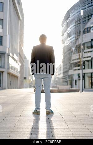 Businessman standing in the city at sunset Stock Photo