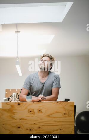 Architect working in office, looking up Stock Photo