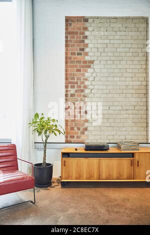 Interior of a loft flat with brick wall and chest of drawers Stock Photo